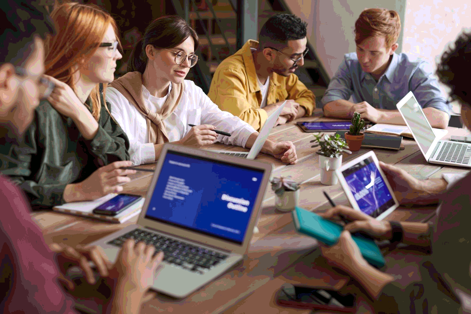 B2B account team collaborating with laptops and tablets