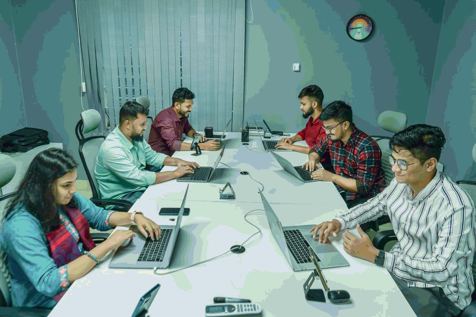 Group of professionals working together on laptops in a modern office workshop