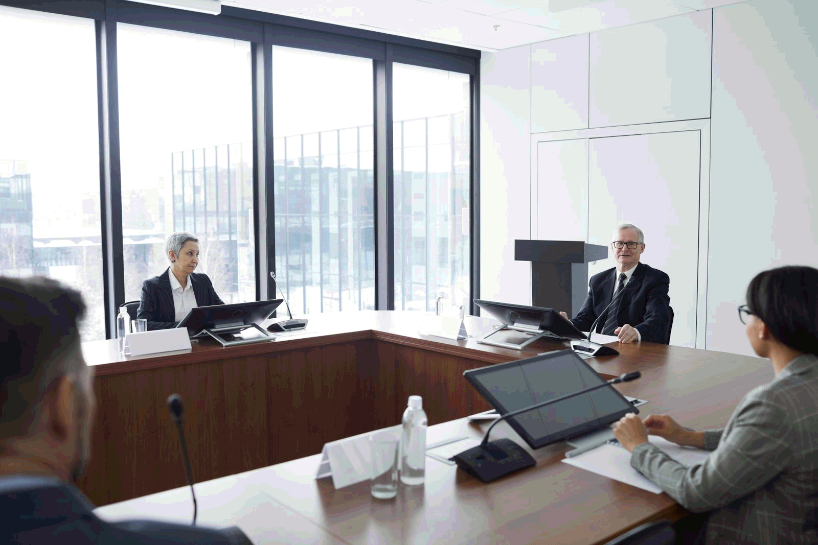 Business professionals engaged in discussion during a board meeting in a modern conference room