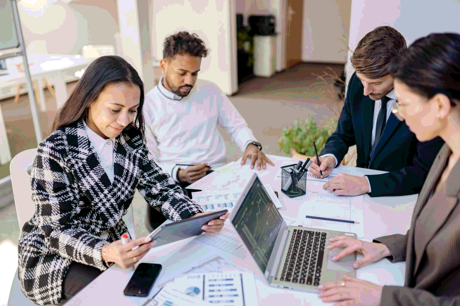 Business team planning and analyzing customer data with laptops in a modern office