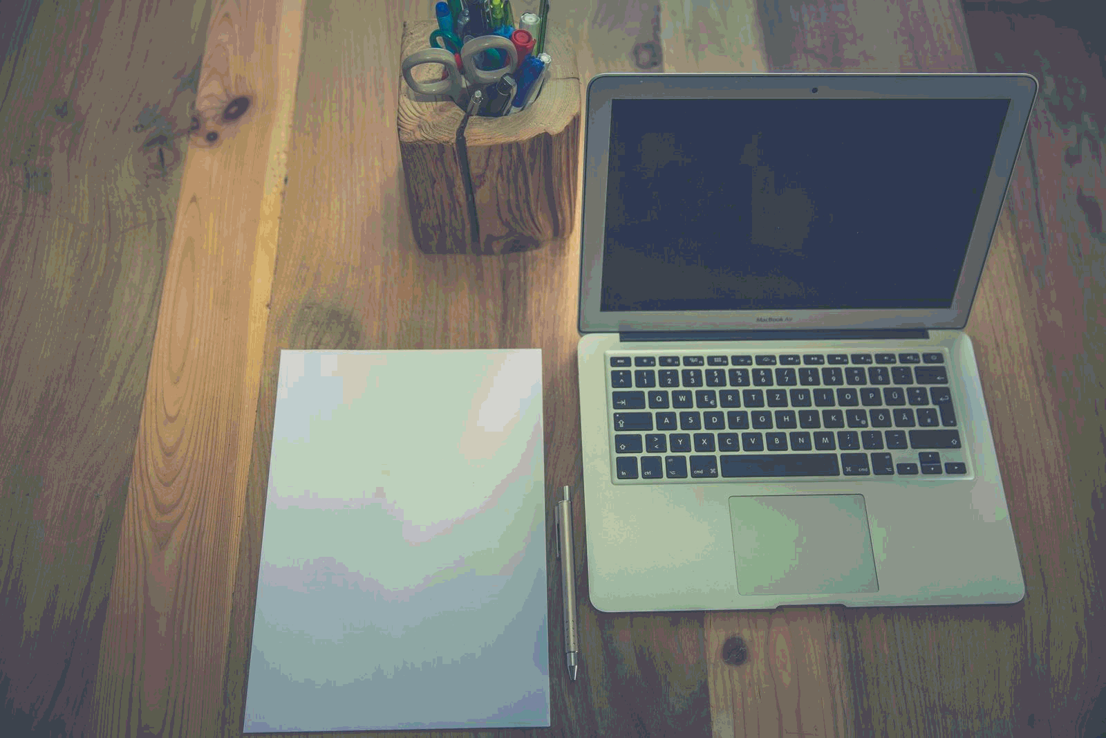 Minimalist documentation workspace with laptop, paper, and stationery on a desk