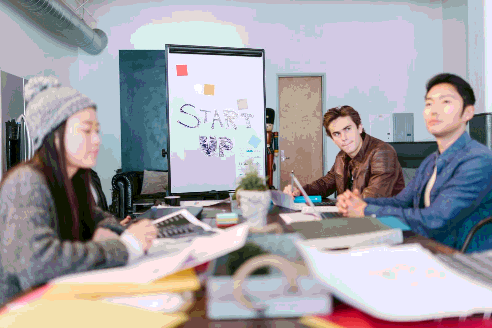 Startup team brainstorming with AI tools and whiteboard