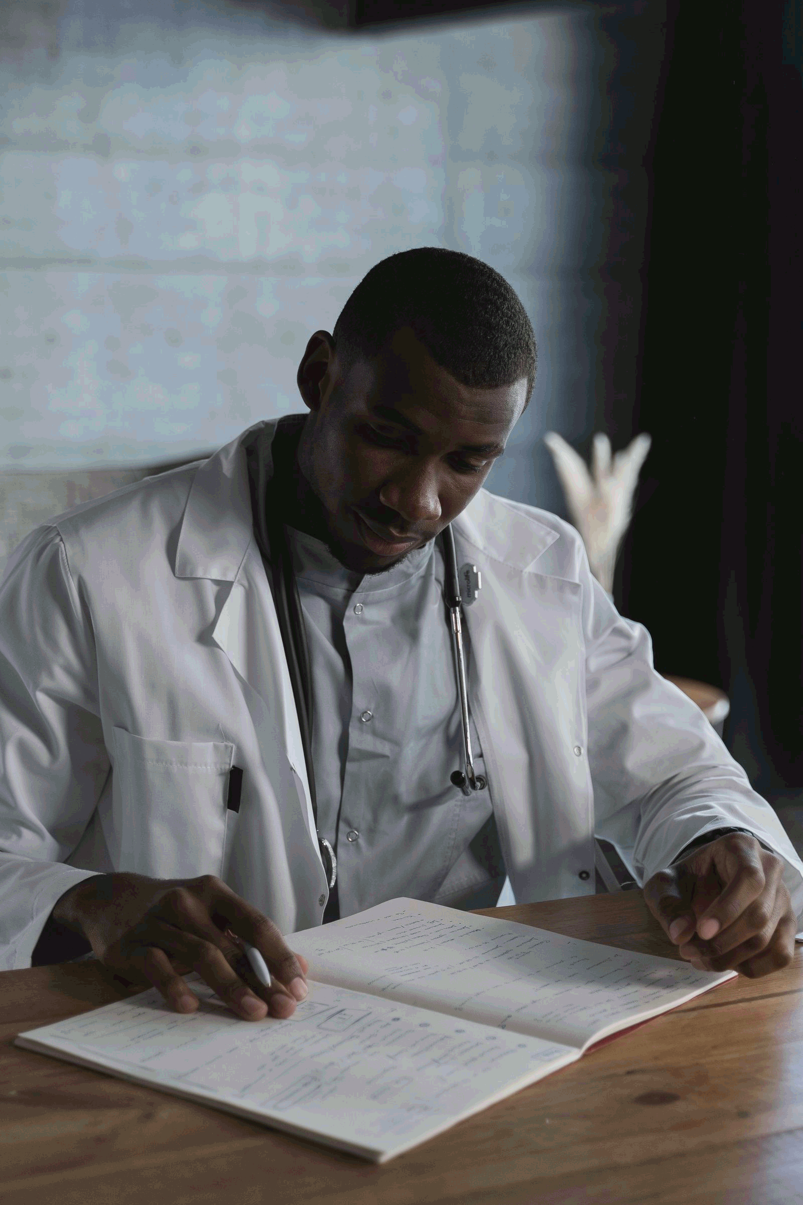 Doctor in a lab coat studying medical records at a desk