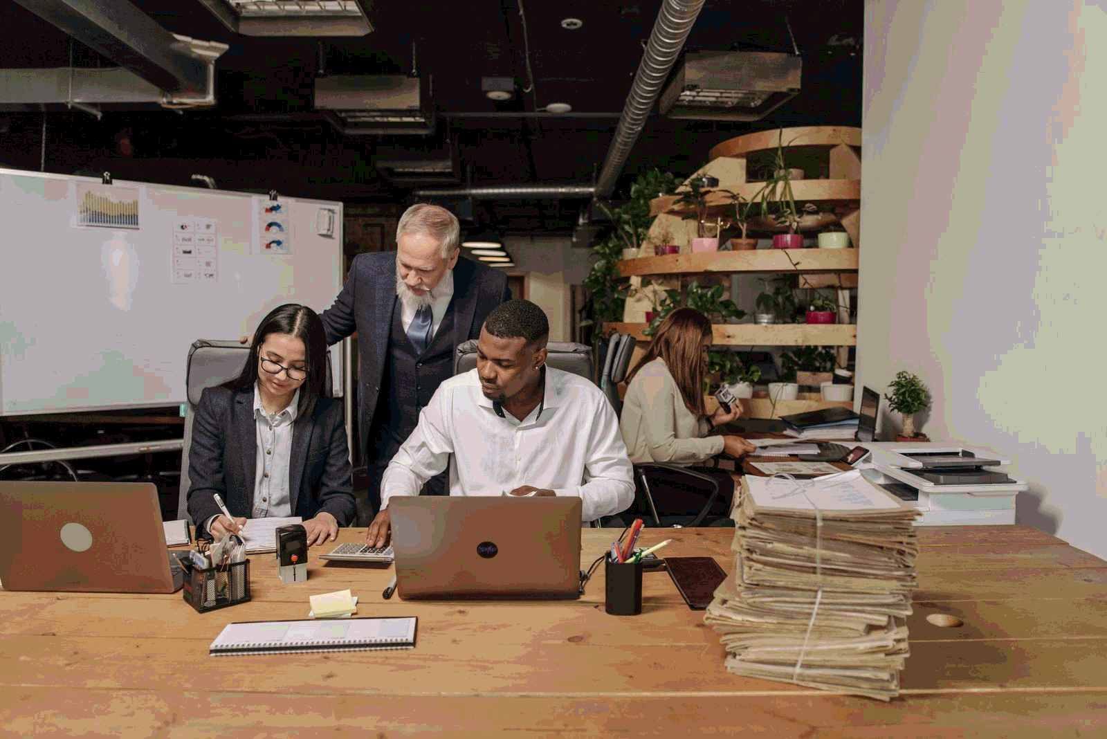 Operations team collaborating with documents and laptops in a modern office