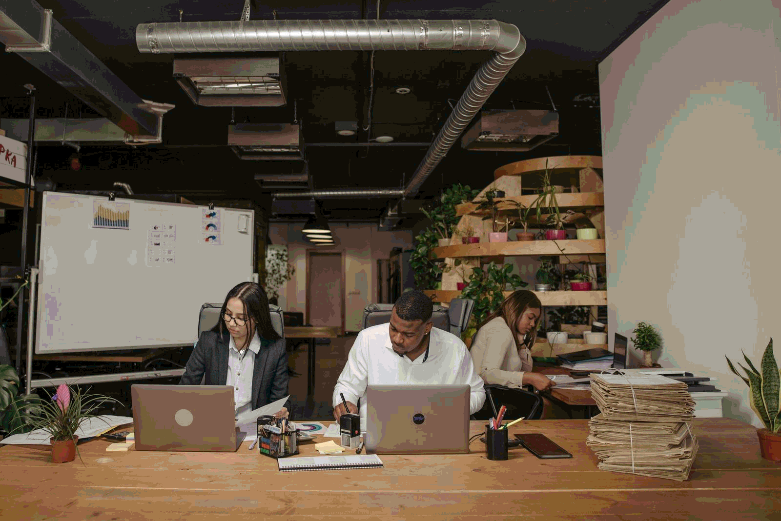 Product managers collaborating around a laptop and documents in a modern office