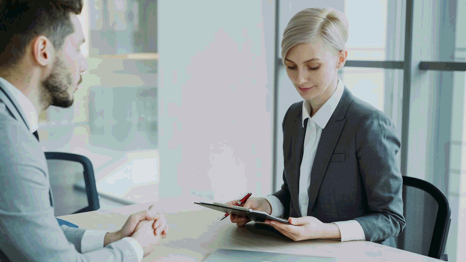 Two professionals discussing business in a bright modern office