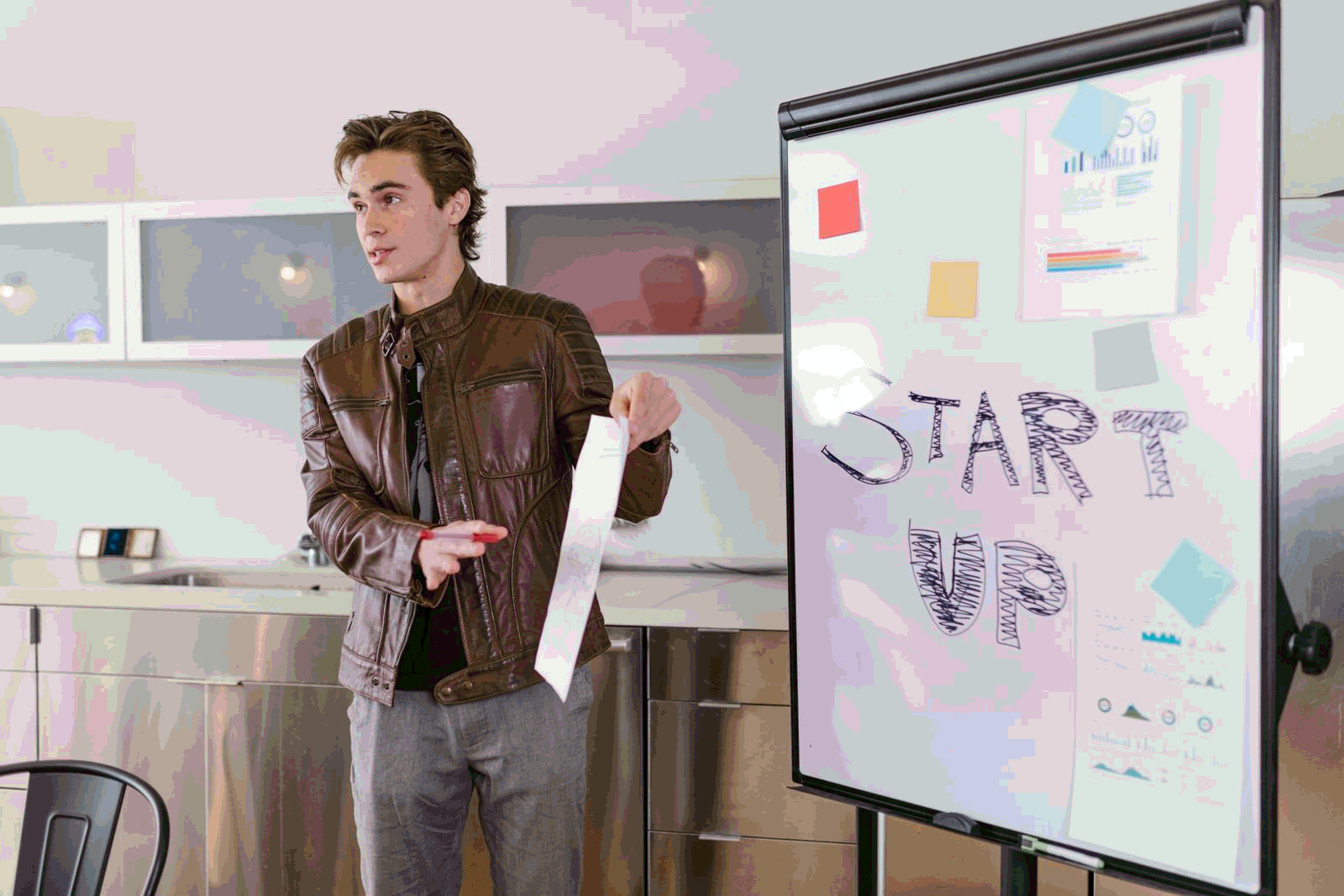 Young entrepreneur presenting startup strategies with a flip chart in a modern office