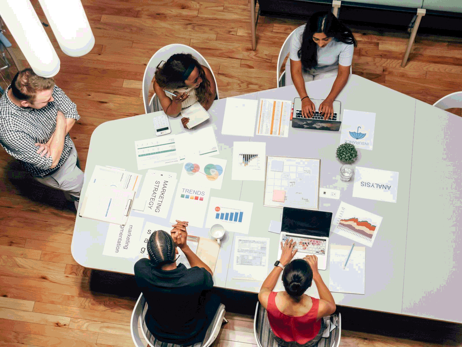 Marketing team reviewing strategy charts and campaign data from above