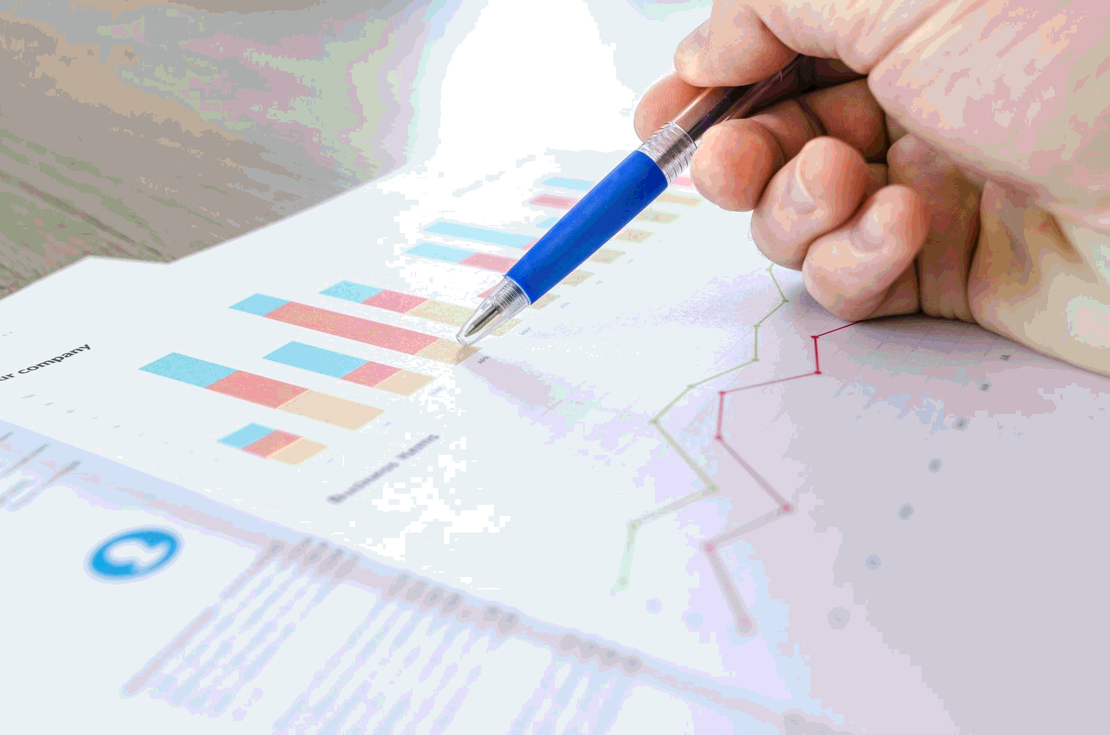 Hand reviewing colorful marketing analytics charts and graphs