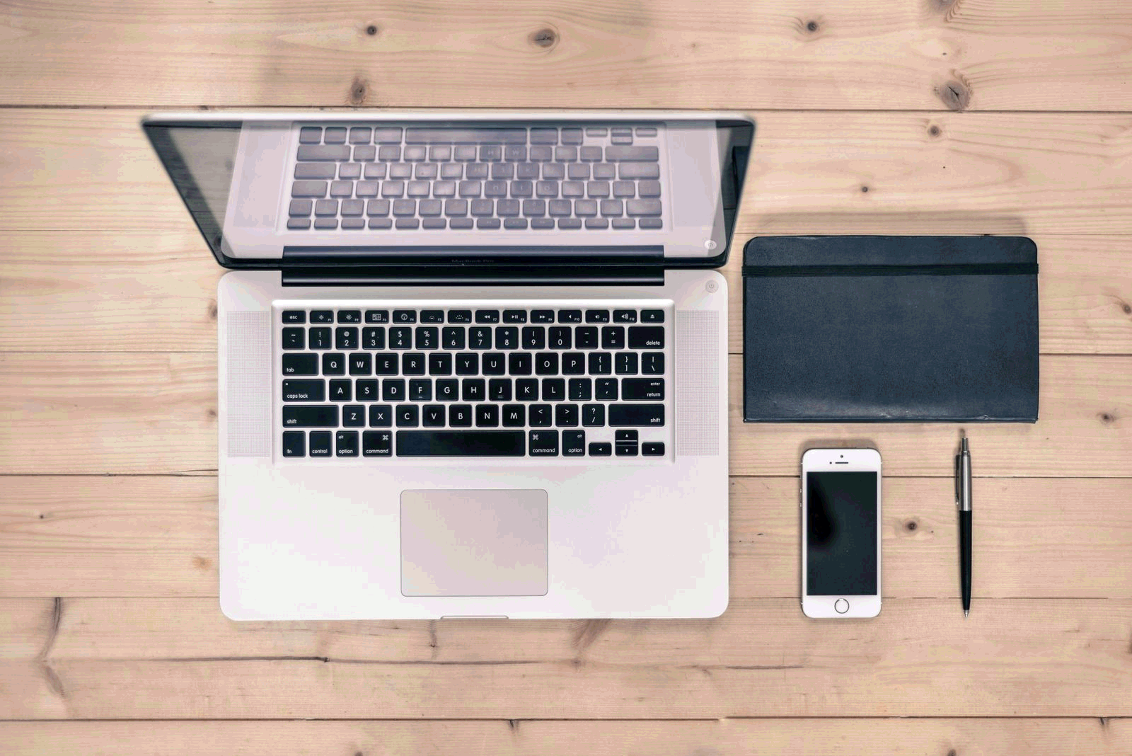 Tidy workspace with laptop, notebook, and pen ready for productive note-taking