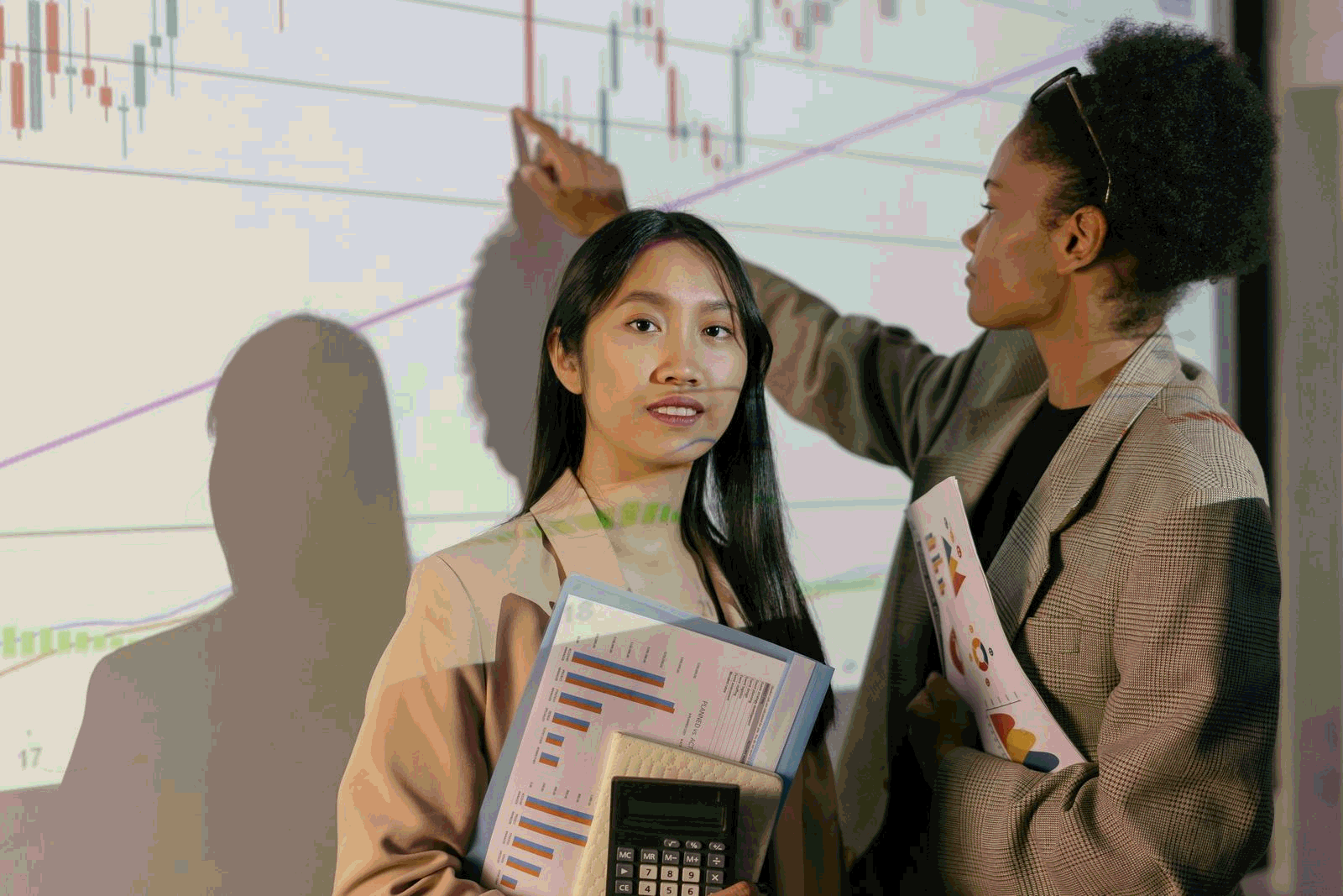 Customer success colleagues reviewing analytics on a large office screen