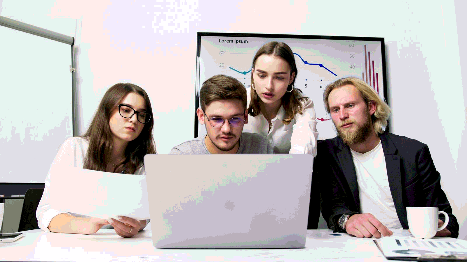 Business team collaborating around a laptop during a negotiation planning session