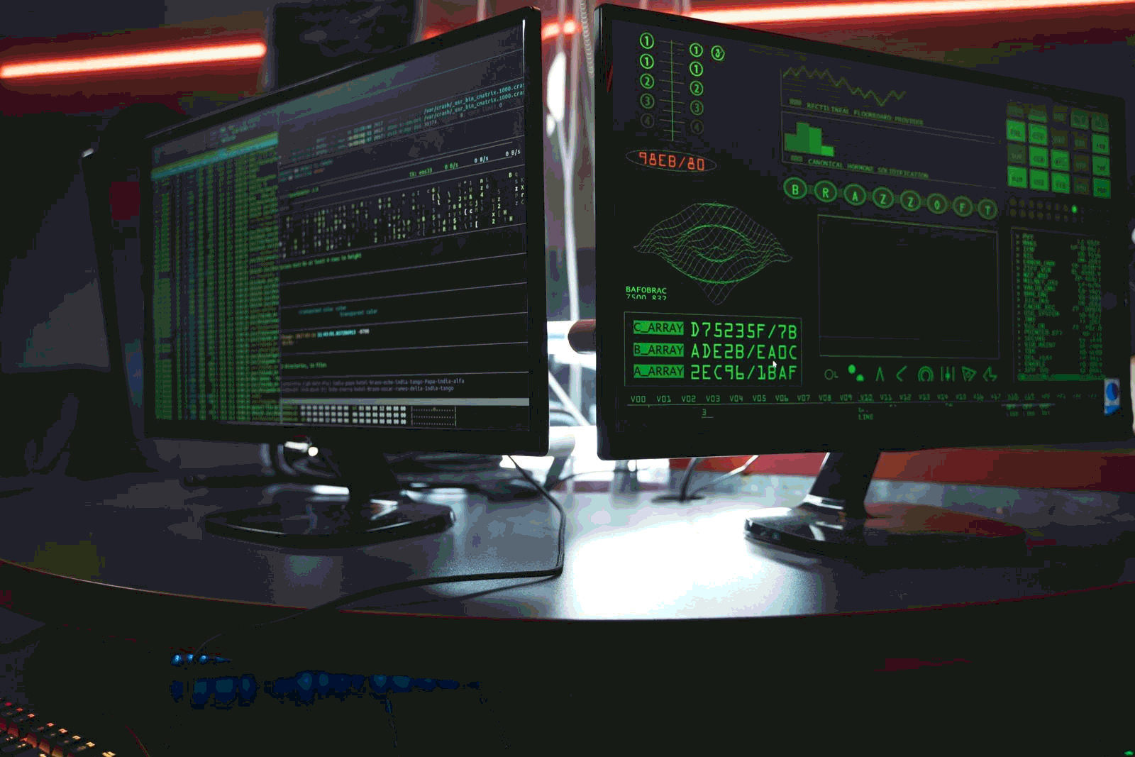 Security operations center with dual monitors showing code and threat monitoring dashboards